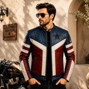 May include: A blue, white, and red leather motorcycle jacket featuring a quilted texture on the upper chest, a dark star emblem on the left chest, and small American flag patches on the sleeves, worn over a plain black shirt with dark trousers.