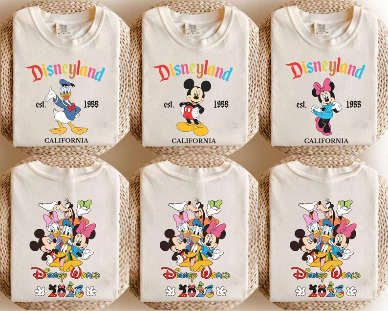 May include: Six off-white t-shirts featuring Disney character graphics. The top row shows Donald Duck, Mickey Mouse, and Minnie Mouse with the text Disneyland est. 1955 California. The bottom row displays a group of characters with Disney World 2026.