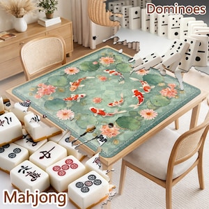Pu&ograve; includere: Un tavolo di legno con un tappeto verde con carpe koi e fiori di loto. I domino sono disposti sul tavolo, con tessere di Mahjong in primo piano. La parola "Dominoes" &egrave; visibile.
