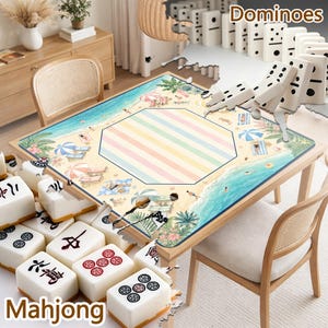 May include: A square game table featuring a beach-themed surface with sand, ocean waves, palm trees, and umbrellas. The center has a pastel striped octagon. White mahjong tiles with black and red symbols are arranged around the table edges.