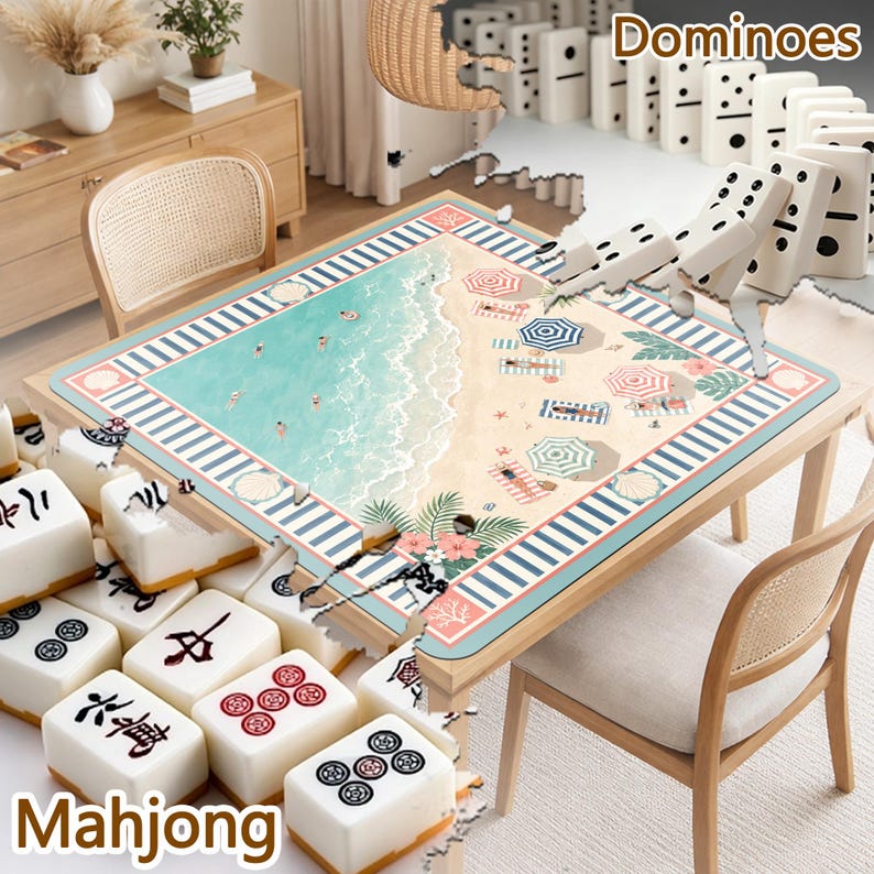 May include: A square table mat featuring a beach scene with turquoise water, sand, umbrellas, and palm leaves, surrounded by a blue and white striped border. The mat is displayed on a wooden table with white mahjong tiles and dominoes nearby.