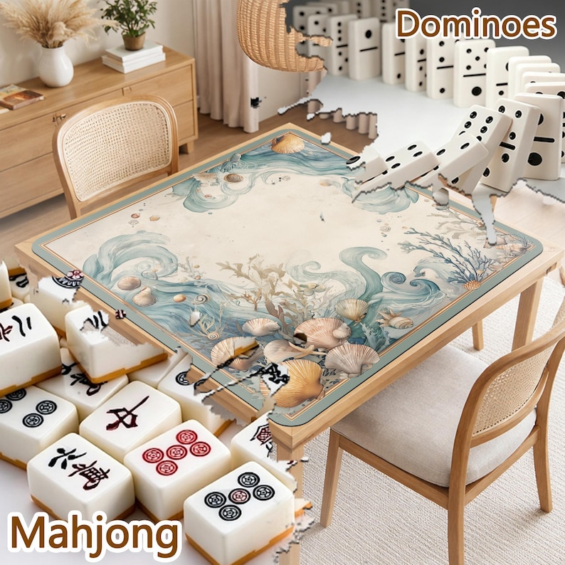 Op de afbeelding: Een tafelset voor spellen, met Mahjong-tegels en dominostenen. De tafel heeft een maritiem thema met schelpen en oceaangolven. Het woord "Mahjong" wordt onderaan weergegeven en "Dominoes" bovenaan. Een stoel met een geweven rug is ook zichtbaar.