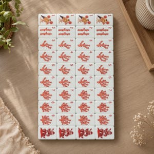 May include: A set of white rectangular mahjong tiles arranged in a grid, featuring red illustrations of coral branches numbered one through nine, with a bird graphic on the top row and a lighthouse graphic on the bottom row of each column.