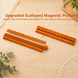 May include: Two brown wooden scalloped magnetic pushers, each featuring a long base and a detachable scalloped edge piece. The text Upgraded Scalloped Magnetic Pusher is visible above the items, along with the phrase Magnets snap the stand and pusher together for super compact storage and easy carry.