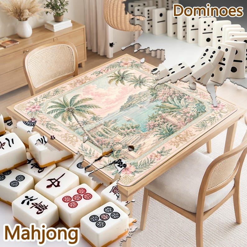 May include: A square table featuring a tropical landscape print with palm trees and a coastal view, surrounded by white mahjong tiles with black and red symbols and a row of white dominoes with black pips arranged on the table surface.