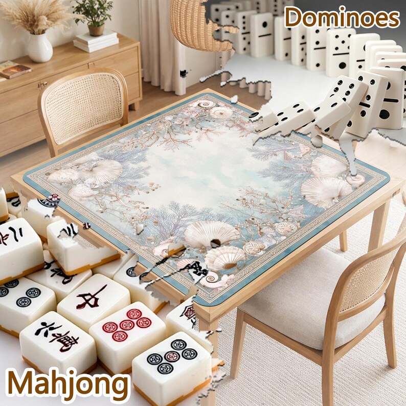May include: A square table mat featuring a light blue and white coastal design with seashells and coral patterns, surrounded by white mahjong tiles with black and red symbols and white dominoes with black dots arranged on the table surface.