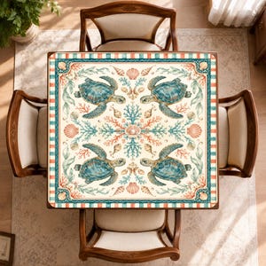 Puede incluir: Un mantel cuadrado con fondo crema que presenta un patr&oacute;n repetitivo de cuatro tortugas marinas de color verde azulado, varias ramas de coral en tonos naranja y azul, y diversas conchas marinas. El borde tiene un dise&ntilde;o de rayas.