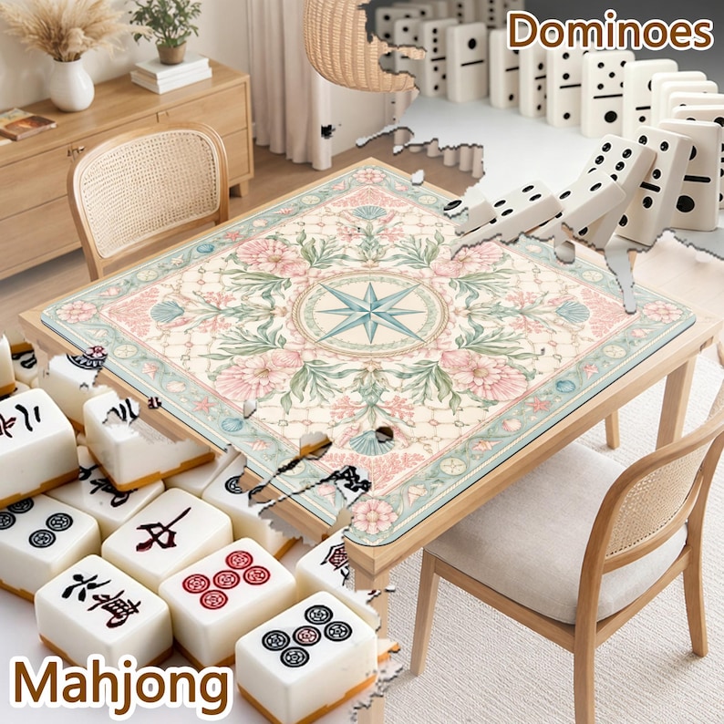 May include: A square game table featuring a cream-colored surface with a central star compass design surrounded by pink floral and green leaf patterns. The table is surrounded by white mahjong tiles with black and red symbols and white dominoes.