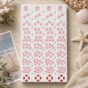 May include: A set of white rectangular tiles arranged in a grid, each featuring pink seashell illustrations corresponding to the numbers one through nine, with a red and white lifebuoy icon on the bottom row of each column.