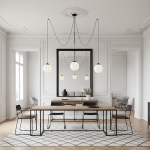 Pode incluir: Uma sala de jantar moderna com uma longa mesa de madeira e cadeiras pretas. Acima da mesa, uma luminária única com várias lâmpadas esféricas de vidro branco pende do teto. Um grande espelho reflete a sala. A mesa tem cerca de 200 cm de comprimento.