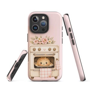May include: A light pink smartphone case featuring a graphic of a vintage-style oven with a smiling bread loaf inside. The oven is decorated with a bouquet of pink flowers on top and a pink and white checkered towel hanging from the handle.