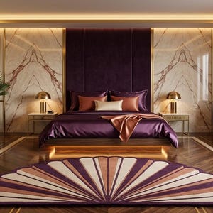 May include: A bedroom featuring a bed with deep purple bedding and orange accents, flanked by two gold lamps on nightstands. A fan-shaped rug with purple and cream stripes lies on the dark wood floor, and a purple chaise lounge sits to the right.