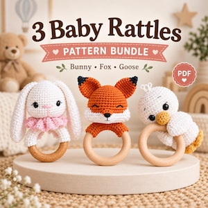 May include: A set of three crochet baby rattles featuring a white bunny with a pink collar, an orange and white fox, and a white goose, each attached to a smooth wooden ring. The text 3 Baby Rattles PATTERN BUNDLE Bunny Fox Goose PDF is visible.