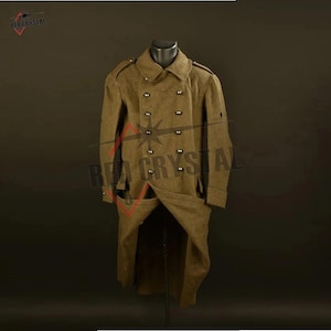 May include: A double-breasted olive drab wool coat featuring a wide collar, shoulder epaulets, and two rows of dark buttons down the front. The garment has long sleeves with cuffs and a structured, knee-length design with a flared lower section.