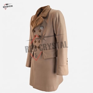 May include: A tan double-breasted coat featuring a brown velvet collar, long sleeves with buttoned cuffs, and two front flap pockets. The coat is adorned with dark brown buttons and a circular silver-toned emblem on the upper chest area.