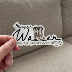 May include: A die-cut sticker featuring the black text Morgan Wallen with a pair of beige cowboy boots integrated into the lettering. Below the name, the text reads STILL THE PROBLEM TOUR with the year 2026 enclosed in a black oval outline.