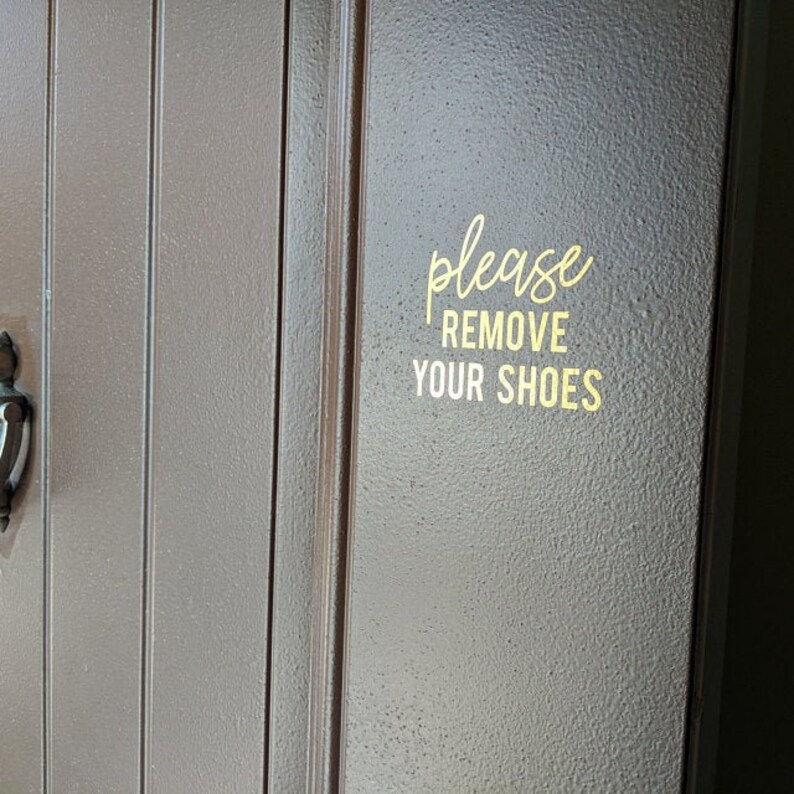 May include: A brown wooden door with a gold sticker that says "please remove your shoes".