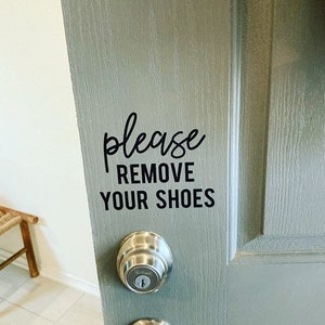 May include: A gray door with a black vinyl sticker that reads "Please Remove Your Shoes".