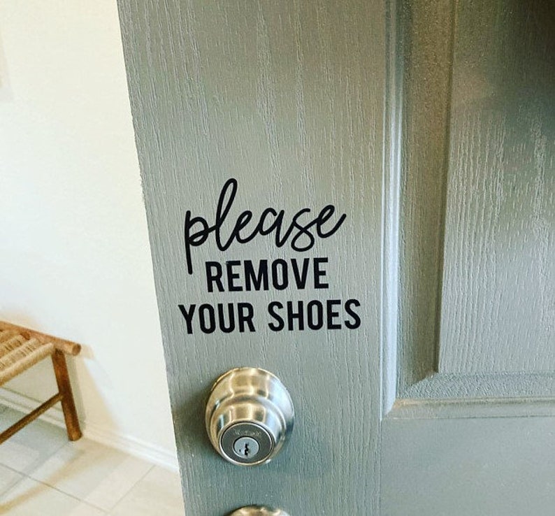 May include: A gray door with a black vinyl sticker that reads "Please Remove Your Shoes".