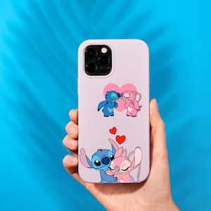 May include: A lavender phone case featuring a cartoon illustration of Stitch and Angel, with hearts. The case has a protective bumper and a camera cutout. The design includes two pairs of the characters, one kissing and the other embracing.
