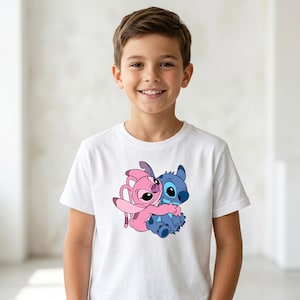 May include: A white t-shirt featuring a cartoon graphic of Stitch and Angel hugging. The characters are in shades of blue and pink. The shirt is being worn by a person.
