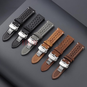 Puede incluir: Seis correas de reloj en varios colores, incluyendo negro, gris y marrón. Cada correa presenta un diseño perforado y un cierre plateado. Las correas son de cuero y tienen costuras blancas.