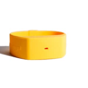 May include: A bright yellow silicone wristband featuring a smooth, matte finish and a small, horizontal rectangular cutout on the front surface. The word 'angel' is embossed in a subtle, matching yellow tone on the side of the flexible band.