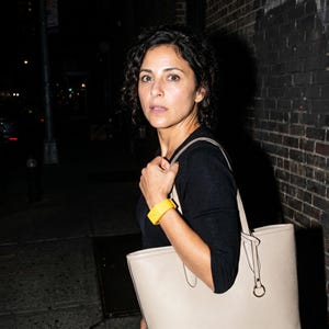 Peut inclure: Un sac cabas beige dot&eacute; de deux bandouli&egrave;res et d'un anneau m&eacute;tallique circulaire, accompagn&eacute; d'un bracelet jaune vif. Le sac pr&eacute;sente une surface textur&eacute;e et est port&eacute; &agrave; l'&eacute;paule, compl&eacute;t&eacute; par un haut noir &agrave; manches longues.