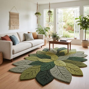 Könnte beinhalten: Ein Wohnzimmer mit einem großen, blattförmigen Teppich in verschiedenen Grüntönen. Der Teppich ist der Mittelpunkt, ergänzt durch ein cremefarbenes Sofa mit bunten Kissen, einen Holztisch und Topfpflanzen. Natürliches Licht fällt durch große Fenster ein.