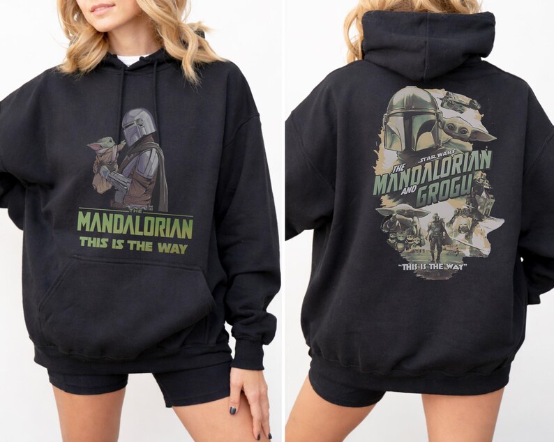 May include: A black hooded sweatshirt featuring a graphic of The Mandalorian and Grogu on the front with the text "Mandalorian This Is The Way". The back displays a larger, detailed illustration of the characters with "The Mandalorian and Grogu" text.