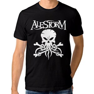 May include: A black short-sleeved t-shirt featuring a white graphic print on the chest. The design displays the word ALESTORM in a stylized font above a skull with octopus-like tentacles and two crossed bones positioned underneath the skull.