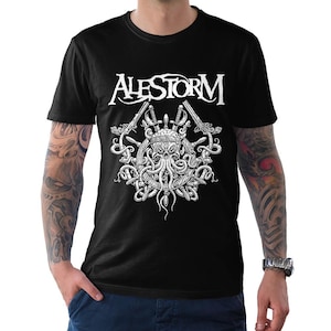 May include: A black short-sleeve t-shirt featuring a white graphic print of the text ALESTORM above a skull with octopus tentacles, a ship's wheel, and crossed swords. The design is centered on the chest of the garment, which has a crew neckline.