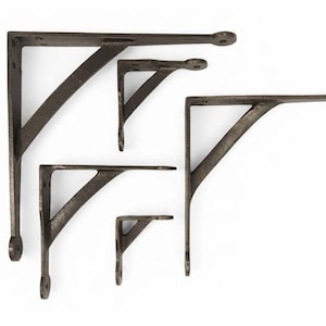 Könnte beinhalten: Ein Set aus fünf L-förmigen Regalwinkeln aus Metall in verschiedenen Größen, jeweils mit einer dunklen, strukturierten Oberfläche, einer diagonalen Stützstrebe und runden Montageenden mit vorgebohrten Löchern zur Wandbefestigung.