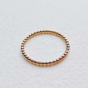 Puede incluir: Un anillo de oro con cuentas de dise&ntilde;o sencillo. El anillo est&aacute; hecho de peque&ntilde;as cuentas redondas que est&aacute;n espaciadas uniformemente.