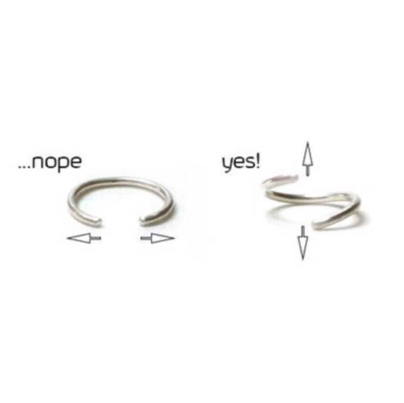 Puede incluir: Un aro de nariz de plata con una abertura con bisagra. La imagen muestra c&oacute;mo insertar el aro correctamente. El texto '...nope' y 'yes!' indica la forma correcta e incorrecta de insertar el aro.