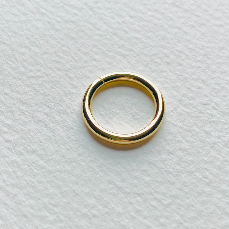 Puede incluir: Un aro para la oreja de color dorado con un acabado liso y pulido.