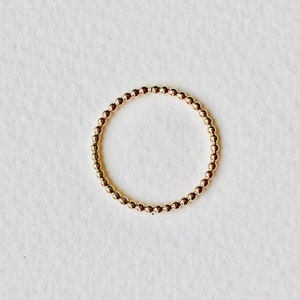 Puede incluir: Un anillo de oro con cuentas de dise&ntilde;o sencillo. El anillo est&aacute; hecho de peque&ntilde;as cuentas redondas que est&aacute;n conectadas entre s&iacute; para formar un c&iacute;rculo.