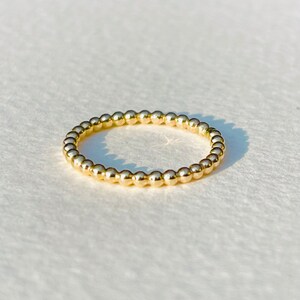 Puede incluir: Un anillo de oro con cuentas de dise&ntilde;o sencillo. El anillo est&aacute; hecho de peque&ntilde;as cuentas redondas que est&aacute;n espaciadas uniformemente.