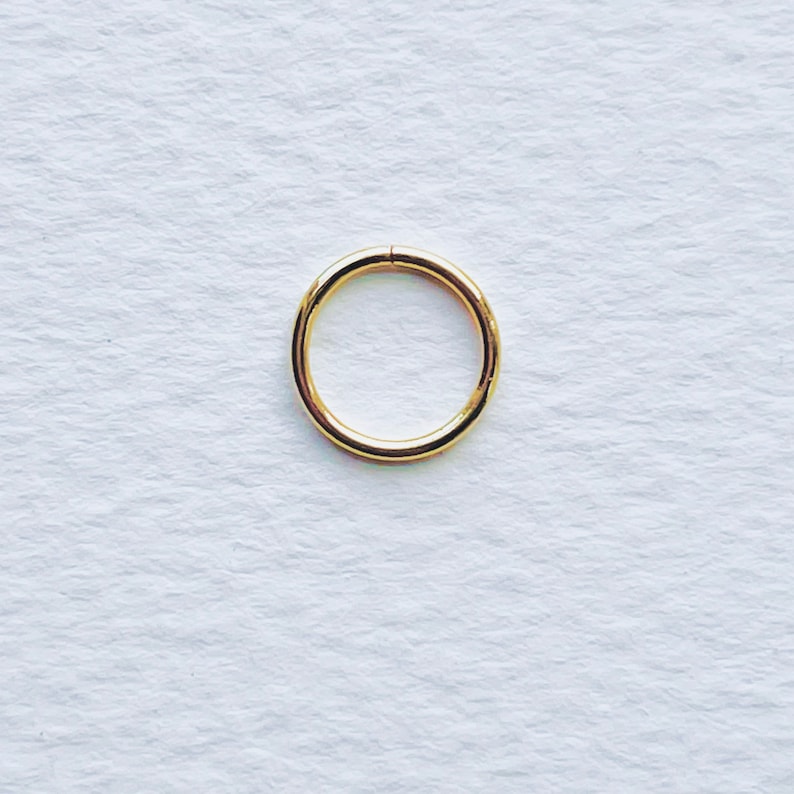 Puede incluir: Un aro para la oreja de color dorado, una opci&oacute;n popular para joyer&iacute;a corporal.