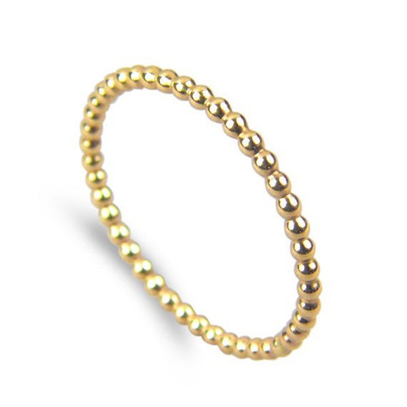 Puede incluir: Un anillo de oro con cuentas de dise&ntilde;o sencillo. El anillo est&aacute; hecho de peque&ntilde;as cuentas redondas que est&aacute;n espaciadas uniformemente.