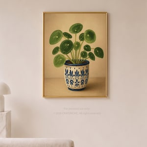 Puede incluir: Una lámina de arte enmarcada que muestra una planta Pilea verde en una maceta de cerámica con motivos blancos y azules sobre un fondo beige. El texto inferior dice: "For personal use only." y "2026 CRAYONCHIC. All rights reserved."