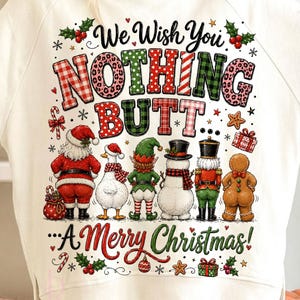 May include: A cream-colored long-sleeve sweatshirt featuring a graphic print with the text We Wish You NOTHING BUTT... A Merry Christmas. The design includes illustrations of Santa, a goose, an elf, a snowman, a nutcracker, and a gingerbread person.