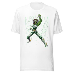 Può includere: T-shirt bianco con un'illustrazione verde e bianca di una figura aliena in posa dinamica. La grafica include un casco verde, un'armatura e un design di sfondo stilizzato. La maglietta è realizzata in materiale morbido.