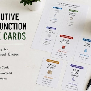 Peut inclure: Un ensemble de cartes de tâches Executive Dysfunction blanches avec des icônes et du texte colorés, incluant Drink Water, Clear One Surface, Take 5 Deep Breaths, Do One Tiny Thing, Run One Errand et Start Bedtime Routine, avec un stylo noir.