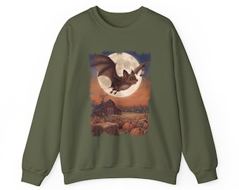 May include: An olive green crewneck sweatshirt featuring a central graphic print of a brown bat flying in front of a large full moon above a red barn, a field of orange pumpkins, and hay bales under a twilight sky with a small flying insect.