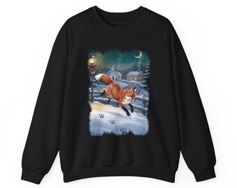 May include: A black crewneck sweatshirt featuring a graphic print of a red fox leaping through deep snow. The scene includes a winter village background with a street lamp, small birds, and a crescent moon in a dark blue night sky.