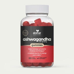 May include: A clear plastic bottle with a white ribbed cap containing red strawberry flavored ashwagandha with ginseng gummies. The black and red label reads Akshar Ayurveda, ashwagandha with ginseng, gummies, 60 vegan gummies, and herbal dietary supplement.