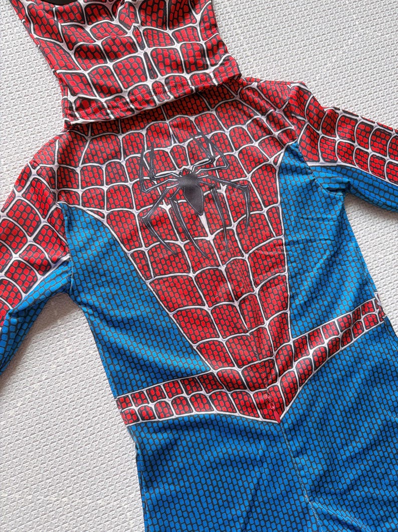May include: A Spider-Man costume with a red and blue color scheme. The costume features a hood and a spider web design on the chest and hood. The costume is made of a lightweight material.