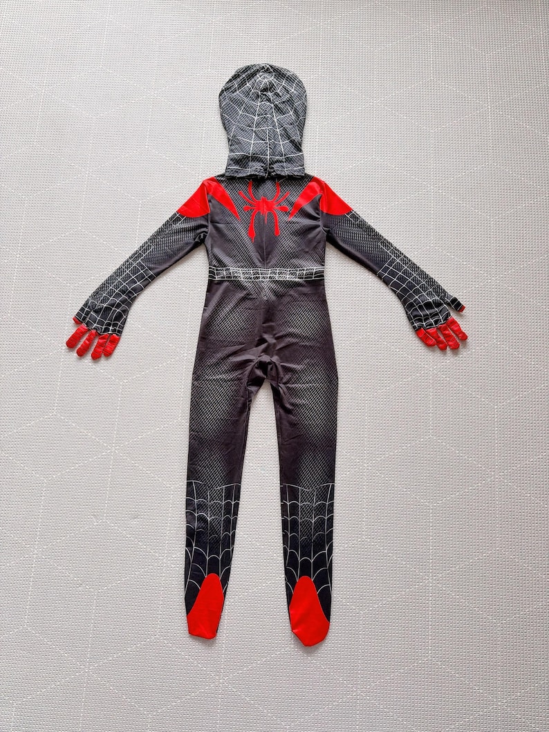 May include: A black and red Spider-Man costume with a hood. The costume features a spider web pattern, red accents on the shoulders, hands, and feet, and a spider emblem on the back. The costume is designed to resemble the character's suit.