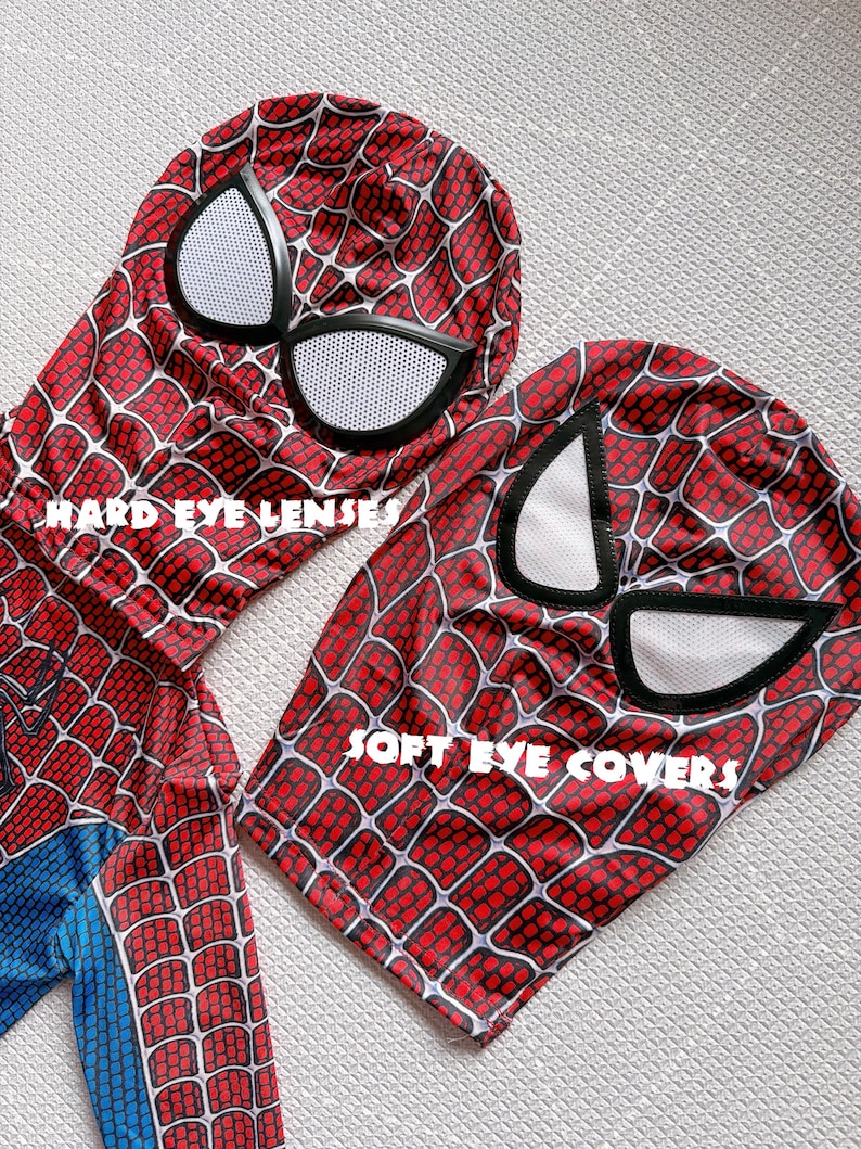 May include: Two Spider-Man masks with red and black web patterns. One mask has "HARD EYE LENSES" printed on it, and the other has "SOFT EYE COVERS" printed on it. The masks have white eye coverings.